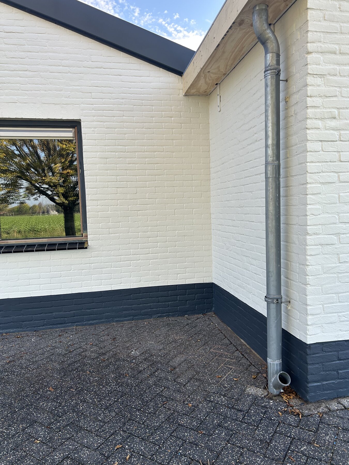 Witte gevel met antracieten plint